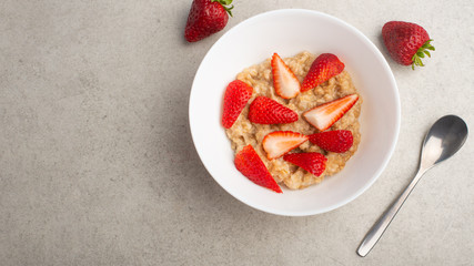 breakfast of oatmeal with strawberries, flat lay