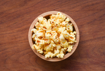 Popcorn in wooden cup bowl and wood backgroubd top view / Sweet butter popcorn salt
