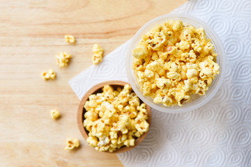 Popcorn in wooden cup bowl and wood backgroubd top view / Sweet butter popcorn salt