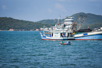 fishing boat at harbor in the ocean sea and mountain background in thailand