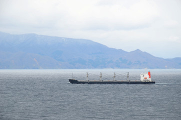 Small cargo ship sailing near Japanese island Hokkaido.