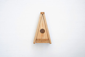 Decorative nesting wood box on white wall background. Little wood birdhouse.