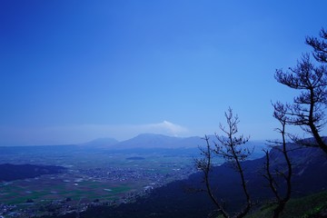 Obraz na płótnie Canvas 噴煙を放つ阿蘇山と阿蘇町の風景