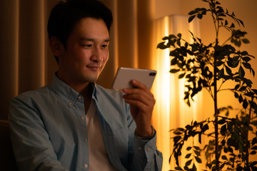 スマートフォンでコンテンツを見る男