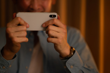 スマートフォンでコンテンツを見る男