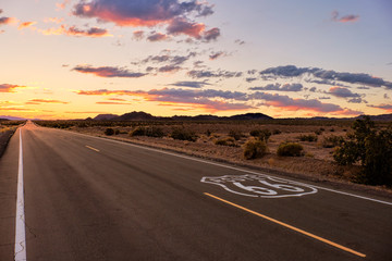 Dramatic sunset over route 66 with the open road going into the Mojave Desert while on a vacation road trip in Southern California. © Ben