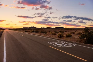  Dramatische zonsondergang over route 66 met de open weg die de Mojave-woestijn ingaat tijdens een vakantie-roadtrip in Zuid-Californië. © Ben