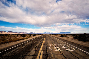 Landscape of cracked and broken pavement of route 66 lin the Mojave Desert.