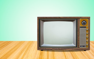 Retro old television receiver on table front gradient green wall background.vintage tv with cut screen on perspective wooden floor..