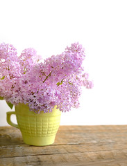 beautiful blooming purple lilac bouquet. spring season, gentle image. lilac branches in mug on wooden table. copy space. soft focus