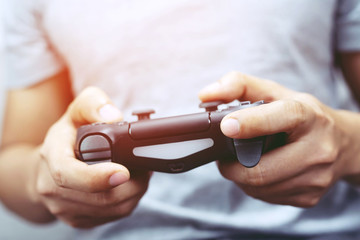 Video game console controller in gamer gaming joystick  in young man hands controller  is playing on the console.  © methaphum