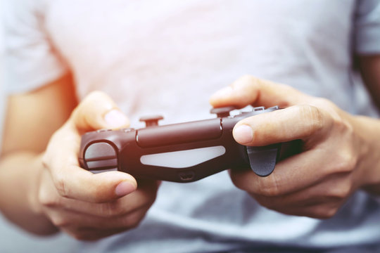 Video game console controller in gamer gaming joystick  in young man hands controller  is playing on the console. 