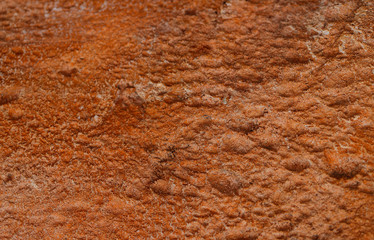 Background texture of red stone with cracks and irregularities. Blur, close-up, top view, plenty of space for text, no one. Concept of design.