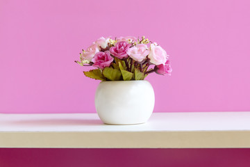 Pink wall with flower pink rose on shelf white wood, copy space for text. Still life Concept