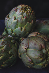 Obraz premium fresh french artichokes at the market. Dark food background