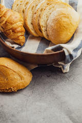 Freshly baked bread on wooden table,Bakery Concept- gold rustic crusty loaves of bread and buns on black chalkboard background. captured from above (top view, flat lay. Layout with copy space