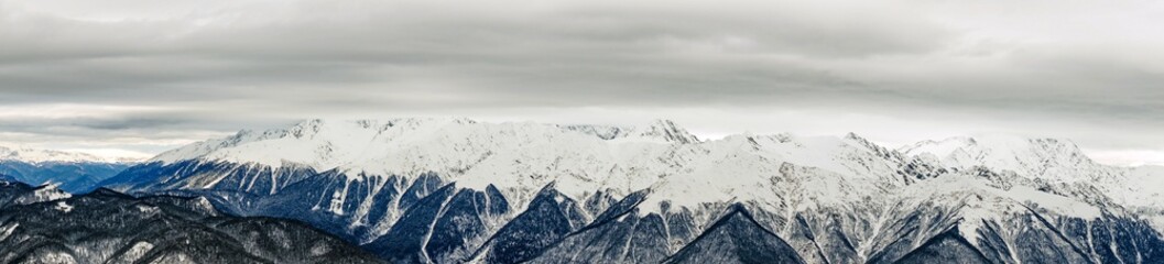 Fototapeta na wymiar Panoramic view of the Caucasus mountains covered by snow in the ski resort of Krasnaya Polyana, Russia.