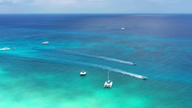 Aerial view from drone on turquoise caribbean sea with floating boats. Travel destination. Summer vacations. Dominican Republic