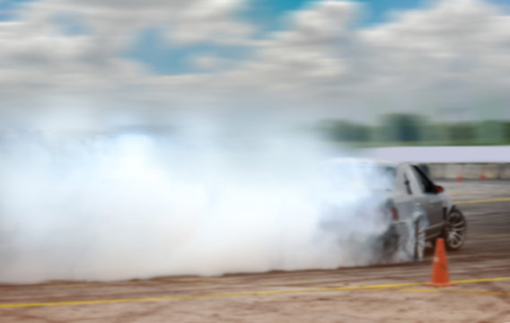Motion-blur of car drifting on speed racing track by professional driver.