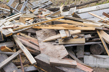 Piled in a pile of debris, pieces of boards, plywood and concrete blocks. Lumber, garbage, firewood