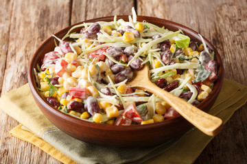 Fresh salad with cabbage, beans, corn, pepper and herbs closeup in a plate. horizontal