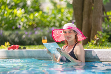 Woman using tablet computer in pool