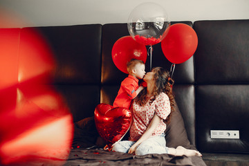 Pregnant woman at home. Mother with son in a bed. Family in a room with decorstions for Valentine's day