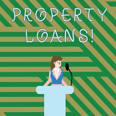 Text sign showing Property Loans. Business photo showcasing a loan used to buy land or buildings and infrastructures Businesswoman Standing Behind Podium Rostrum Speaking on Wireless Microphone