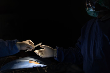 Doctors team working in surgery room, sending  device to eah other to use in operation. Concept for hospital and health care