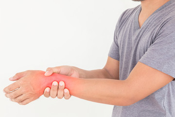 Young man suffering from wrist pain on white background, Health concept.