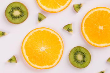 Naklejka na ściany i meble Orange and kiwi slices on a light background. Fruit background. Fruits sliced on a light background.