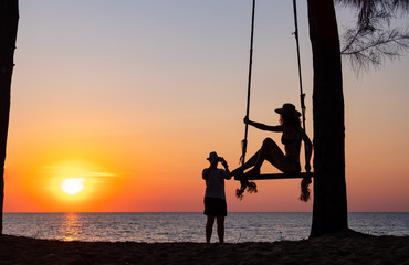 Young couple taking photos on the beach