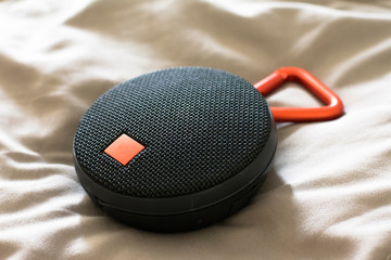 Round bluetooth speaker on the bed