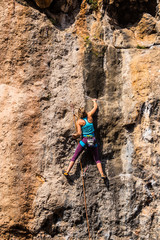 Fototapeta premium A girl climbs a rock.
