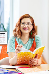 Delighted nice young woman enjoying her studying