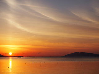 湖に浮かぶ船と夕日