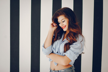 Glamour girl in a studio. Pretty brunette in a pin up clothes. Lady in a blue shirt.