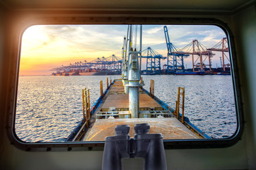 view from window bridge wheelhouse of the incoming ship arrival to an international port for loading discharging and transit the shipment cargo being for logistics system and transport to worldwide © ID_Anuphon