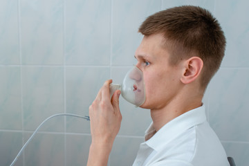 Young man wearing an inhalation mask. Use nebulizer and inhaler for the treatmen