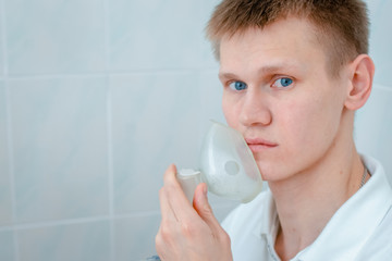 Young man wearing an inhalation mask. Use nebulizer and inhaler for the treatmen