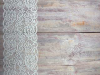 Wide white laces on a brown wooden background vertically in row