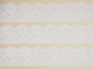White laces on a beige background horizontally in three row