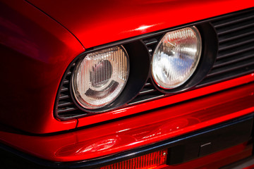 Headlights of a red, old, retro car, closeup