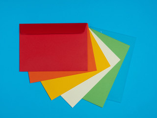 Red, orange, yellow, ivory, green, blue envelopes on a blue background