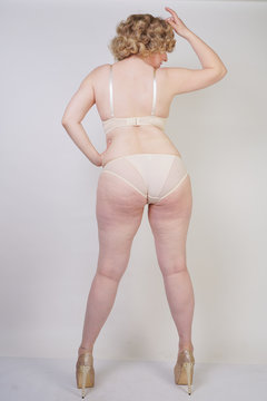 pretty caucasian chubby woman with plus size body and pale skin wearing underwear fashion lingerie on white studio background