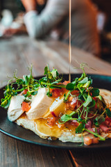 Delicious pancakes on wooden table with mozzarella and greens