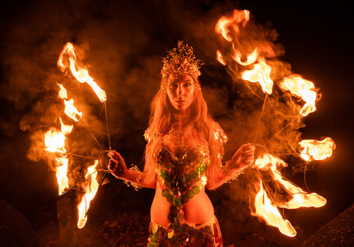 Fire woman posing with burning funs