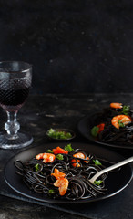 Squid ink pasta with prawns and tomatoes