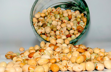close up of dried kidney beans pour out from a jar with white background.
