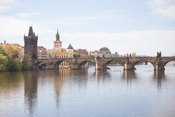 Old Charles bridge and buildings. Vltava river with glare. Travel photo 2019.